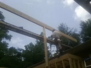 Carpenter setting a ridge beam over a new addition frame — Ice Dam Removal by Roofing Brothers in Roxbury Crossing