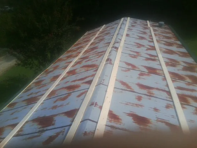 Rusted metal roof panels with new wood purlins before replacement — Storm Damage Roof Repair in Roxbury Crossing by Roofing Brothers