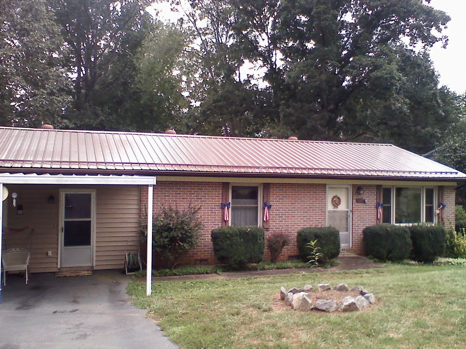 Bronze metal roof and carport on a brick ranch home — Roof Repair work by our crew in Roxbury Crossing