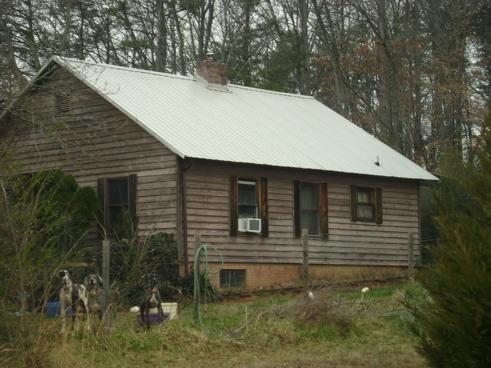 White metal roof on an old wood sided farmhouse, from a Metal Roof Installation job in Roxbury Crossing